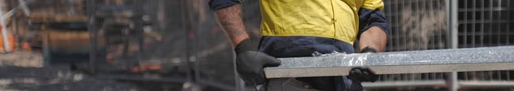 worker on jobsite moving metal