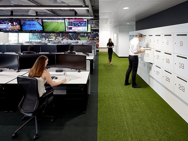 woman by computer screens and man at locker