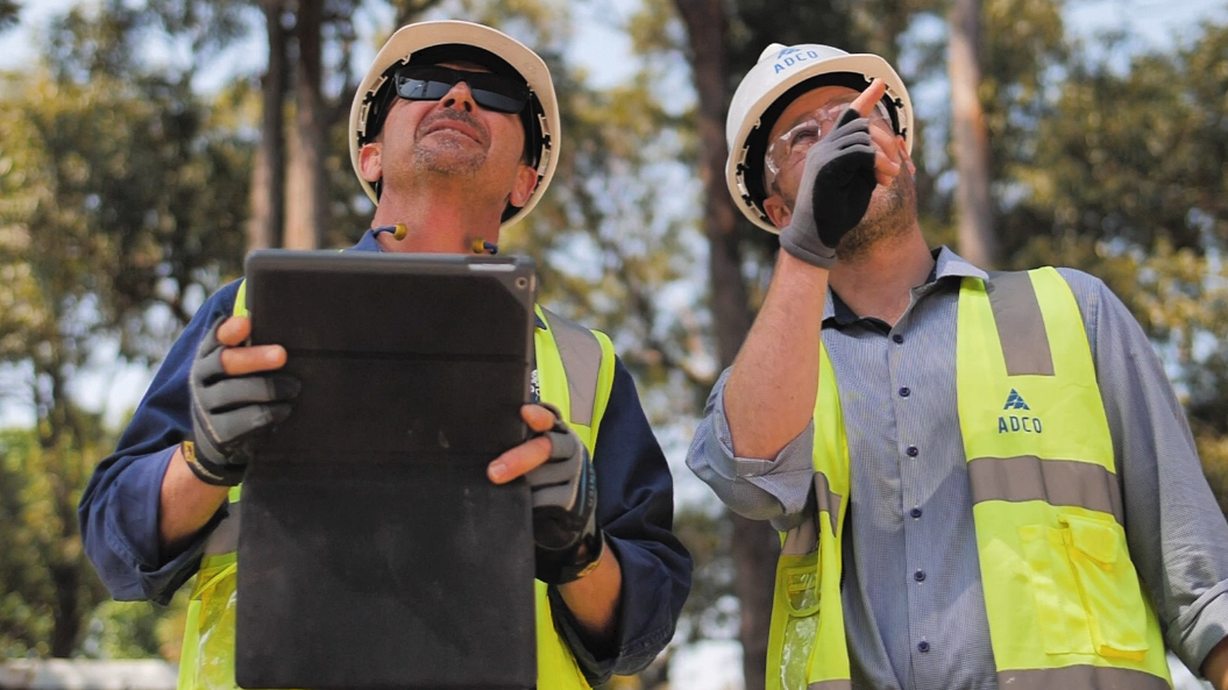 workers on jobsite with tablet
