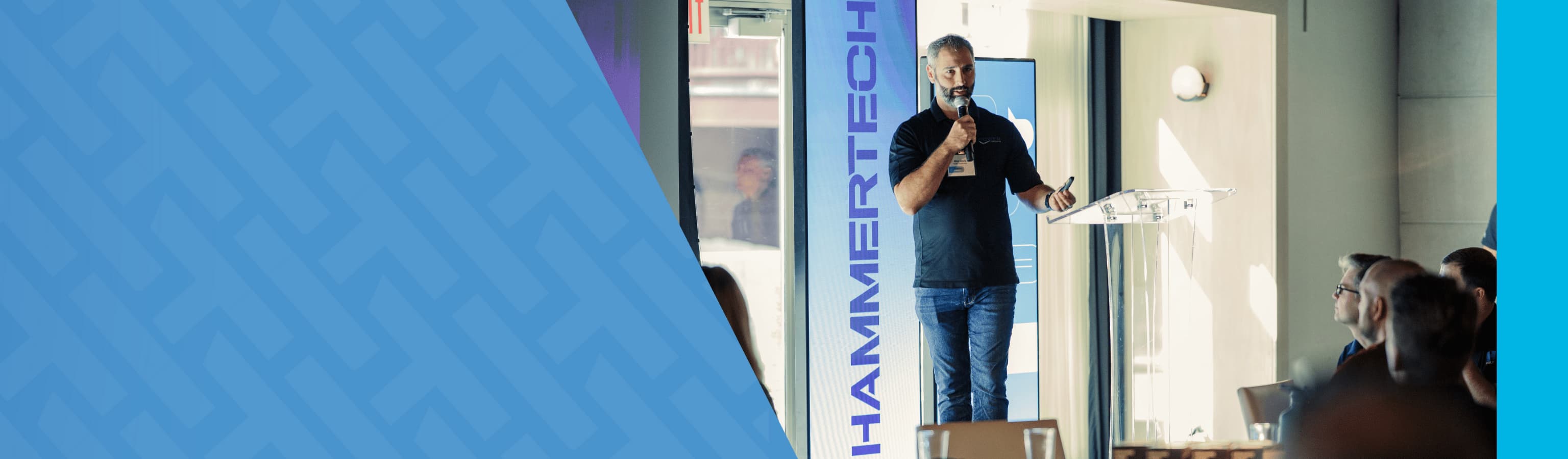 Speaker on stage speaking at the NoAm community event for the blog header.