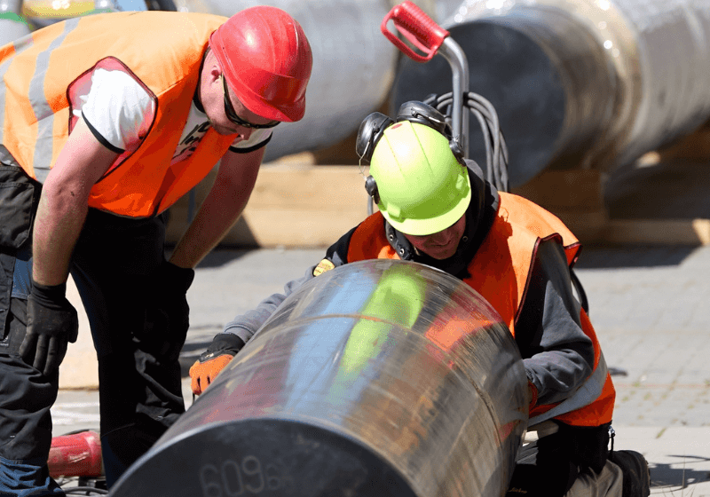 Image of two Civil and Infrastructure construction workers on the job site using HammerTech Construction Safety Software Platform for safety..