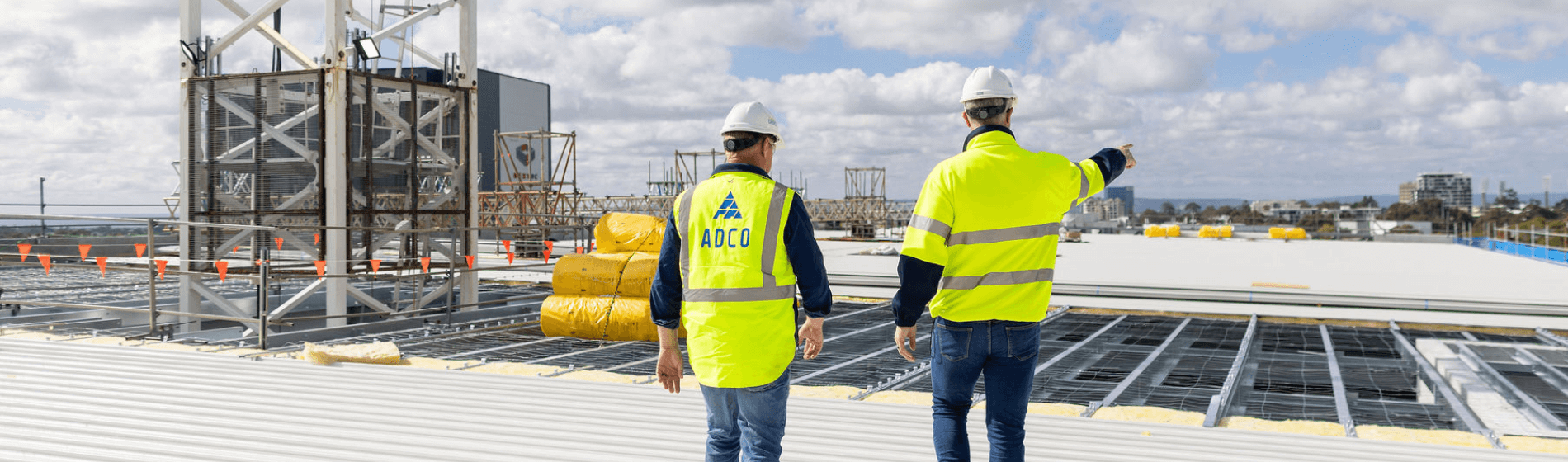 Image of two ADCO works on the top of an in-progress data center build using HammerTech for construction safety.