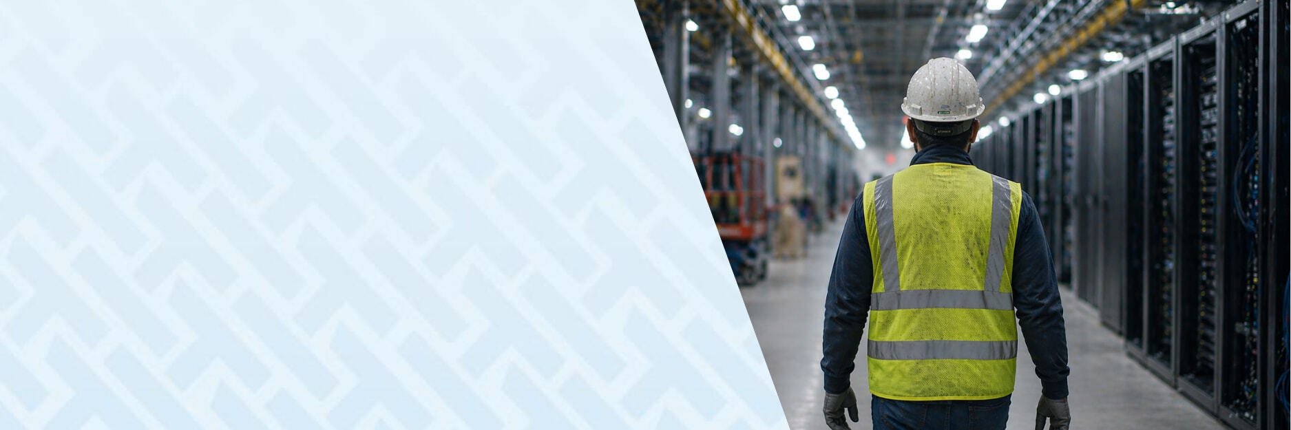 Shows a construction worker walking through a live data center project.