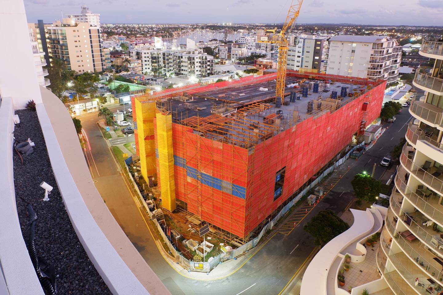 Image of in-progress multi-story 700-story car park being built with a crane in the center. 