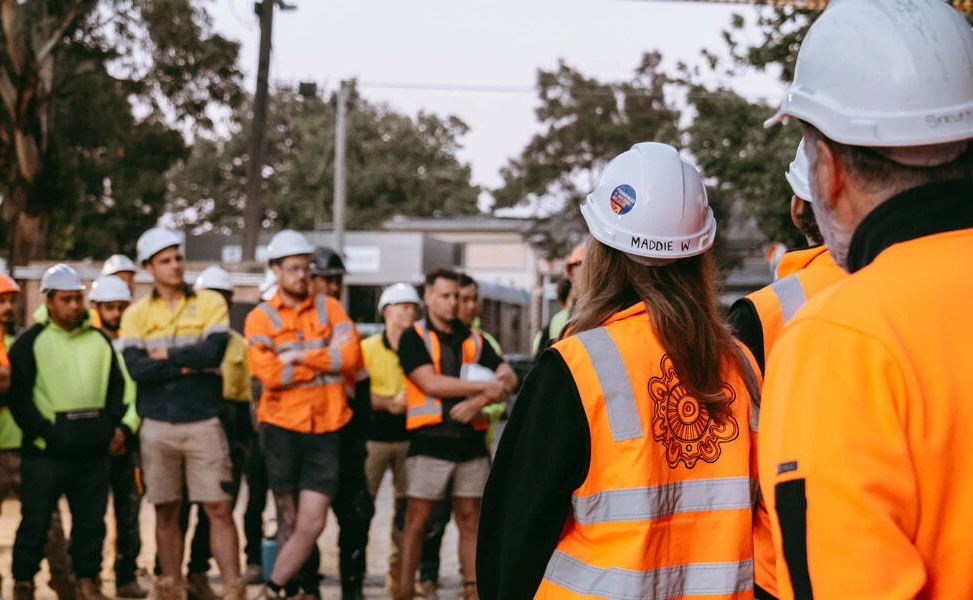 Australian construction crew on site with site manager discussing the safety needs of the day - all wearing proper PPE and using HammerTech