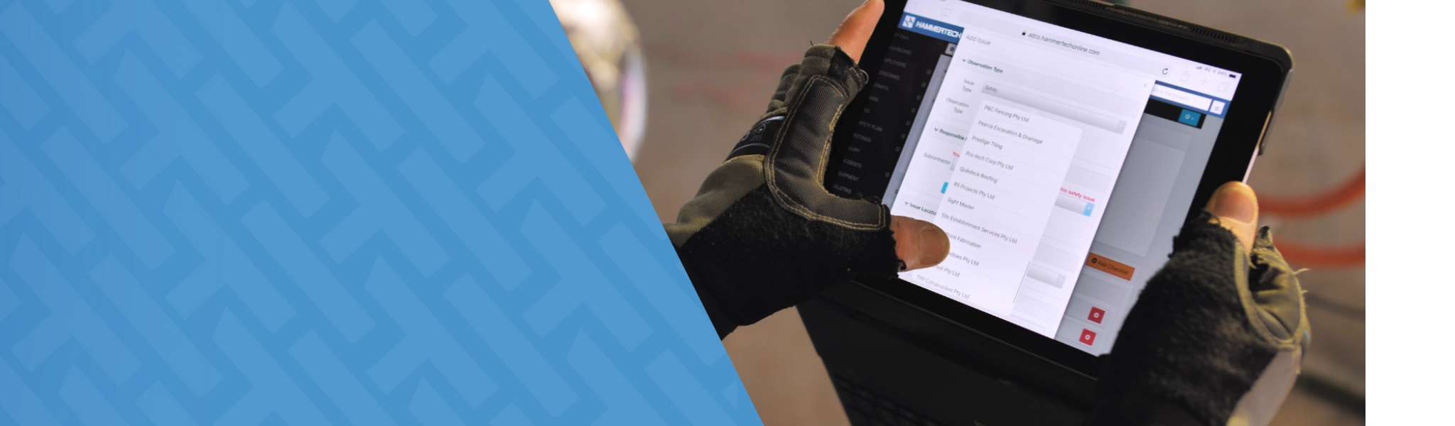 A construction worker wearing black work gloves holds a tablet displaying the HammerTech platform, with a dropdown menu open to select a subcontractor or company within an issue reporting form.