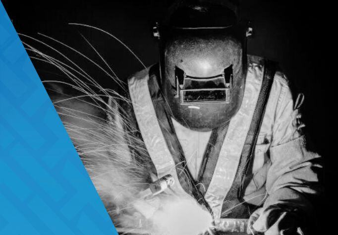 Image of a welder wearing proper PPE to do hot work on a construction site safely.