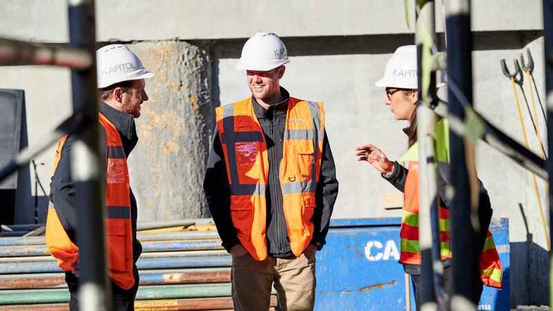 Kapitol Group Construction Workers on Job Site discussing safety while using HammerTech construction safety software.