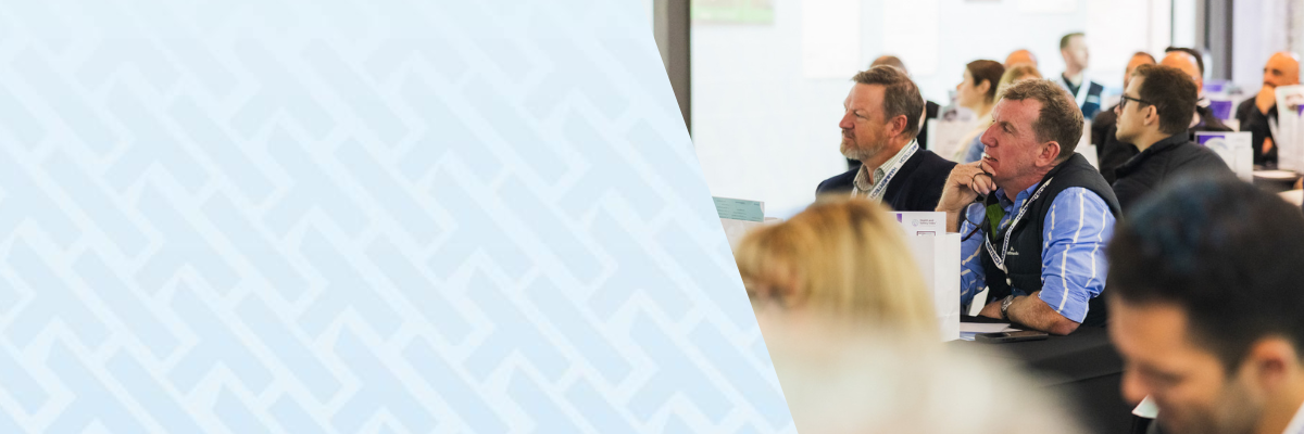 Construction professionals attending a HammerTech construction technology safety session, seated at tables and listening attentively during a workshop or conference presentation.