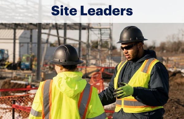 Two commercial construction site leaders on the job site talking about safety and HammerTech construction safety software with ironwork erected behind them.
