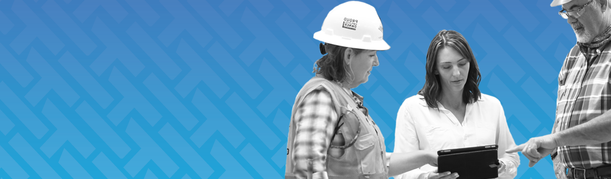 two women in construction working with a guy, looking and planning on an iPad.